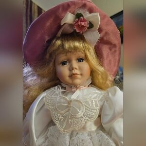 Delicate porcelain doll dressed in pink & white